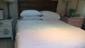 A neatly made bed with white bedding in a room with a wooden headboard. - Serenity Room located inside the Ivory Mansion
 (L'Anse)