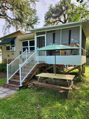 A house with a covered deck, a staircase, and a wooden bench. - Affordable Old Homosassa!  Close to the action and the boat ramp! (Homosassa)