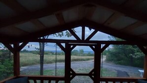 Ein überdachter Sitzbereich mit Blick auf eine ländliche Landschaft.