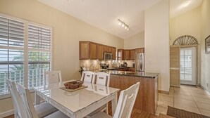A modern kitchen with wooden cabinets, stainless steel appliances, and a central island. - 2BR Cottage Bayside Close to the Pool (Longboat Key)