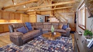 A spacious living room with a large sectional sofa, a wooden ceiling, and a staircase leading to another level. - 'Away at Moose Bay' Breezy Point Gem w/ Game Room (Breezy Point)