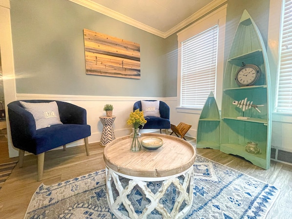 Relax in this inviting living room with a cozy atmosphere, featuring two armchairs, a coffee table, and a decorative wall piece.