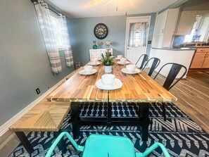 Enjoy a formal dining experience with a long table set for a meal, surrounded by comfortable chairs and elegant decor.