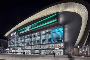 A modern building with a curved facade, large glass windows, and a prominent entrance area.