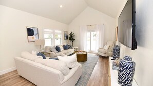 A modern living room with a large sofa, a coffee table, and a TV. - A Modern luxury oasis on the plaza (Oklahoma City)