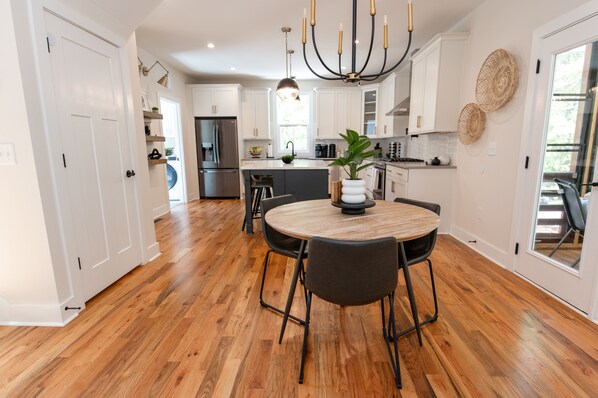 Enjoy cooking in this well-equipped kitchen with a central island, round table, and stainless steel appliances.