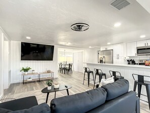 A modern living room with a grey sofa, a coffee table, and a TV mounted on the wall.