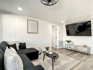 Relax in this stylish living room with a black sofa, coffee table, and flat-screen TV.