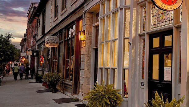 A street view of a building with a sign for 'Grand Gourmet' and 'Ron Wilkin Jewellers.' - Victorian Apartment in the heart of Elora (Elora)