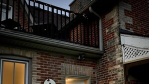 A brick house with a wooden deck, a white door, and a sign that reads "The Victorian." - Victorian Apartment in the heart of Elora (Elora)