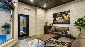 Un salon chaleureux avec un décor intérieur en bois, un canapé, une table basse et un tableau accroché au mur.