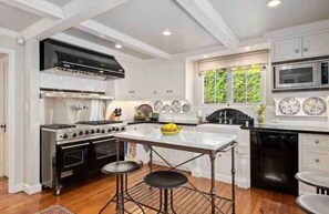 A kitchen with a central island, a stove, and a dishwasher.