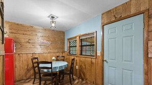 A small dining area with a wooden wall, a blue door, and a red refrigerator. - Cozy and Private Smoky Mountain escape-perfect for a romantic getaway (Cosby)