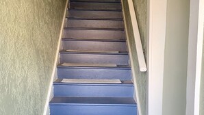 A staircase with blue steps and a white handrail, leading to a door. - Downtown 3 Bed Loft Apartment (Delaware)