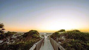 A wooden boardwalk leading to a beach with dunes and vegetation. - Beach Mode: ON — Garden-Level 1BR Just Steps to the Surf (St. Augustine Beach)