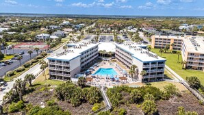 Ein Hotel mit zentral gelegenen Pool, mehreren Balkonen und Blick auf die umliegende Nachbarschaft.