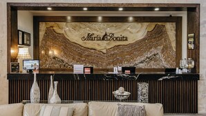 A reception desk with a marble wall and the name "Maria Bonita" in the center. - Hotel María Bonita Chihuahua (Chihuahua)