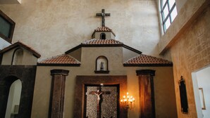 A church interior with a cross, a crucifix, and a lit candelabra. - Hotel María Bonita Chihuahua (Chihuahua)