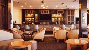 A bar area with seating and a TV screen. - Hotel María Bonita Chihuahua (Chihuahua)