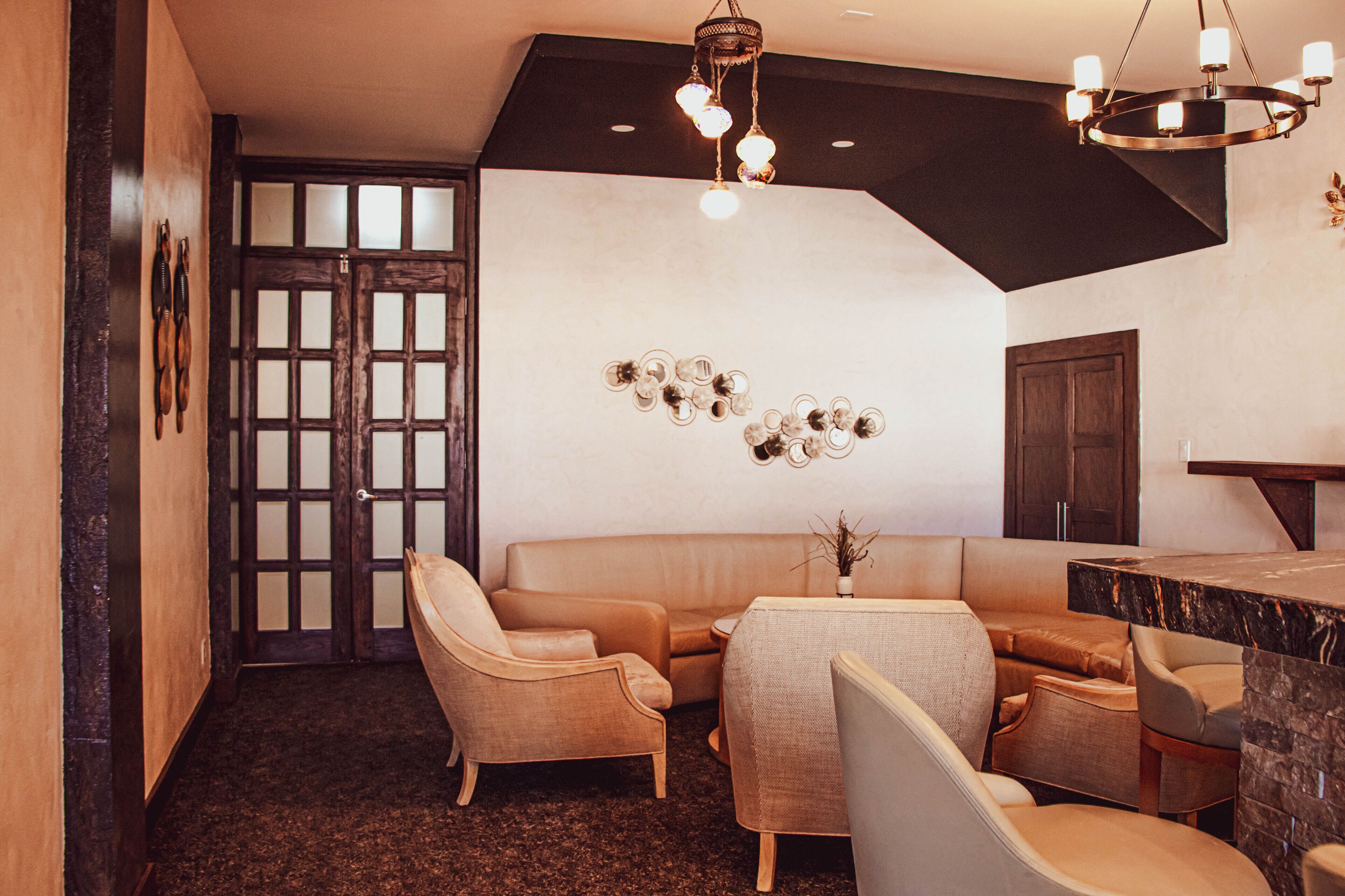 Un interior moderno con una zona de estar, un bar y una pared decorativa.