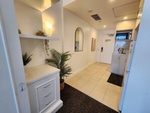 A hotel room with a kitchenette, a small dining area, and a bathroom.