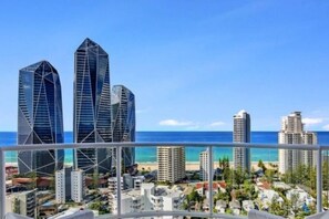 A coastal cityscape with modern skyscrapers and a beach.
