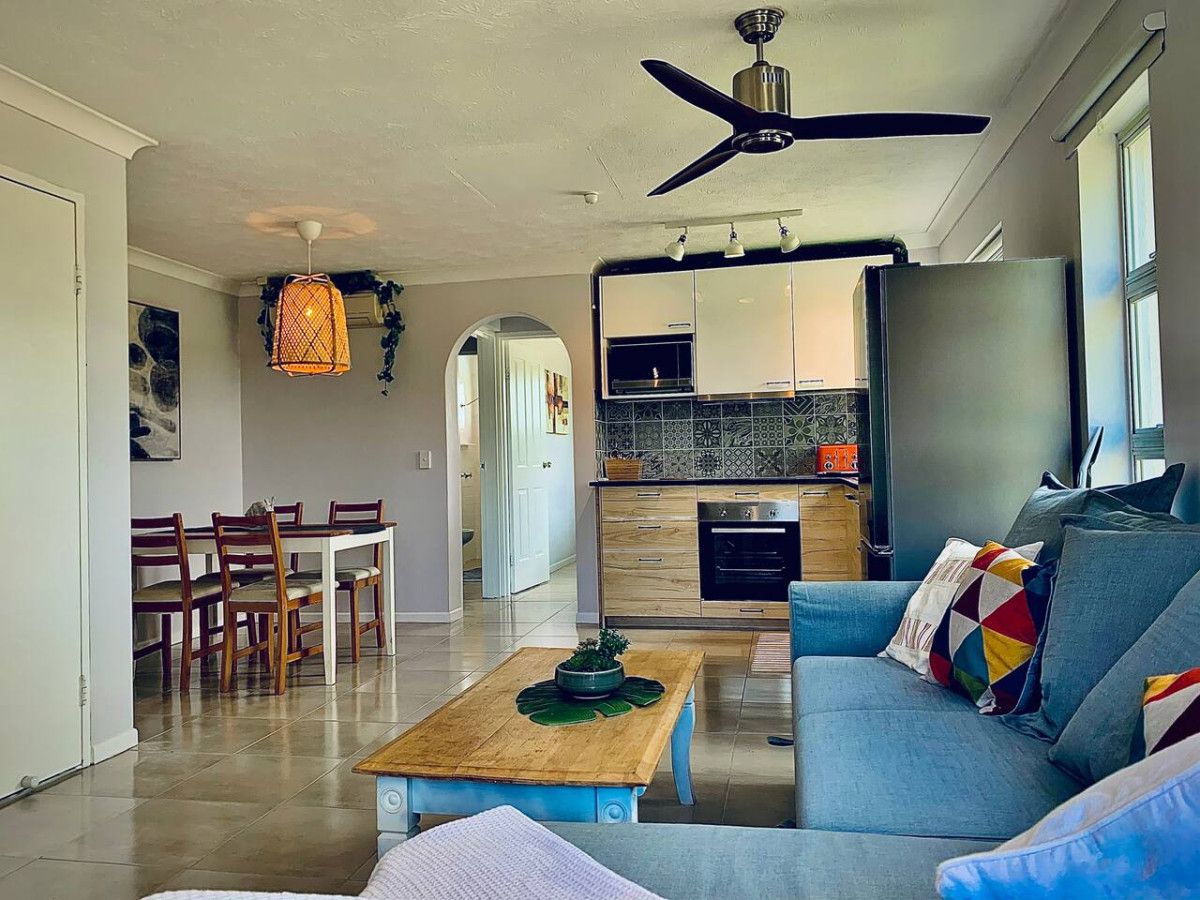 A modern living room with a sofa, coffee table, and dining area.