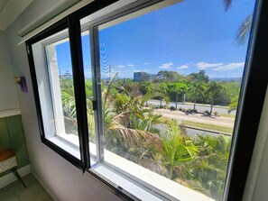 A room with a large window overlooking a parking area and greenery.