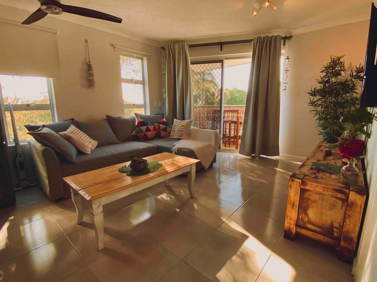 A spacious living room with a sofa, a coffee table, and a wooden side table.