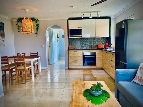 A modern kitchen with wooden cabinets, a built-in oven, and a refrigerator.