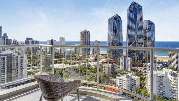 A balcony with a view of a cityscape, including tall buildings and a beach. - Oaks Hotel - Deluxe Studio Apartment - Ocean Views (Surfers Paradise)