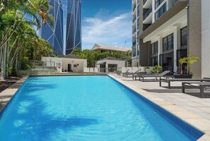 Relax by the pool surrounded by lush greenery and modern architecture.