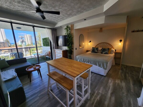 A modern bedroom with a bed, bedside table, and a view of the city.