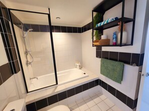 Enjoy a refreshing shower or soak in the standalone bathtub in this bathroom, featuring a walk-in shower and toilet.