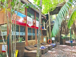 A spa with a large sign, outdoor seating, and tropical plants. - [Holiday Apartment] In Ramada Resort- Port Douglas (Port Douglas)