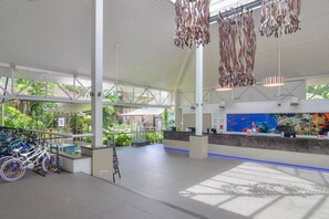 A spacious indoor area with a reception desk, bicycle racks, and an aquarium. - [Holiday Apartment] In Ramada Resort- Port Douglas (Port Douglas)