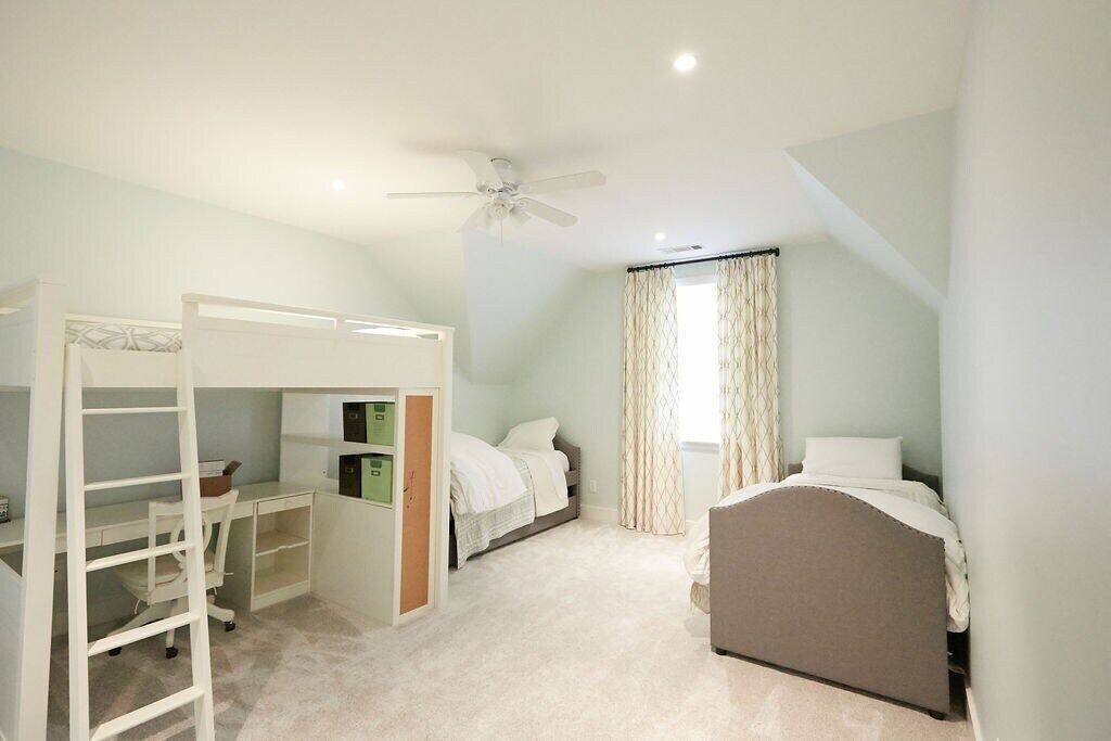 Une chambre avec des lits superposés, un bureau et un lit.