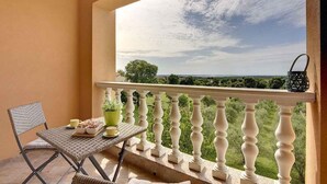 A balcony with a table and chairs, a potted plant, and a view of the landscape. - Holiday apartment with air conditioning (Vodnjan)