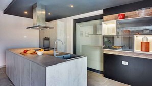 A modern kitchen with a central island, stainless steel appliances, and a sleek design.