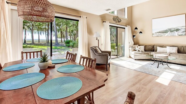 A spacious dining area with a wooden table set for four, surrounded by chairs. - Exceptional 2 Bed/2.5 Bath Marshside Villa in Gated Resort! 5-Min Bike Ride to Private Beach Access! (Fernandina Beach)
