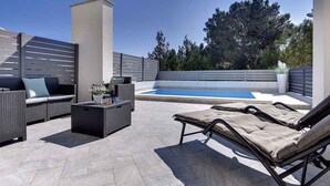 A rooftop patio with outdoor furniture, a swimming pool, and a view of trees. - Holiday home with terrace and pool (Ližnjan)