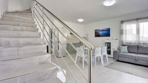 A modern interior with a staircase, a dining area, and a living room. - Holiday home with terrace and pool (Ližnjan)