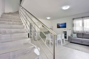 Een modern interieur met een trap, een eetgedeelte en een woongedeelte.