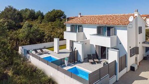 A modern two-story house with a swimming pool and outdoor seating area. - Holiday home with terrace and pool (Ližnjan)