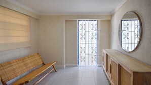 Une pièce comprenant un banc, un miroir et une porte ornée de barreaux décoratifs.