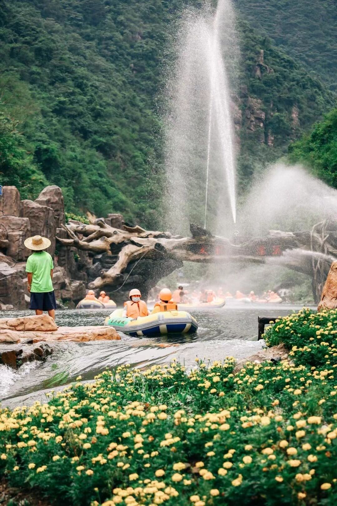 Un grupo de personas haciendo rafting en un río con una cascada al fondo.