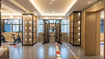 A modern gym with exercise equipment, a pull-up bar, and a fitness wall.