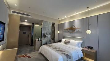 Una habitación de hotel moderna con cama, mesita de noche y televisión.