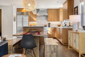 A modern kitchen with wooden cabinets, a stainless steel refrigerator, and a central island with seating. - Walk to Ski! Luxury Telluride Townhome | Walk to Gondola, Main Street & River Trail |  | Sleeps 8 (Telluride)