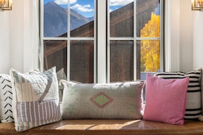 A window seat with four cushions and a view of mountains and autumn foliage. - Walk to Ski! Luxury Telluride Townhome | Walk to Gondola, Main Street & River Trail |  | Sleeps 8 (Telluride)